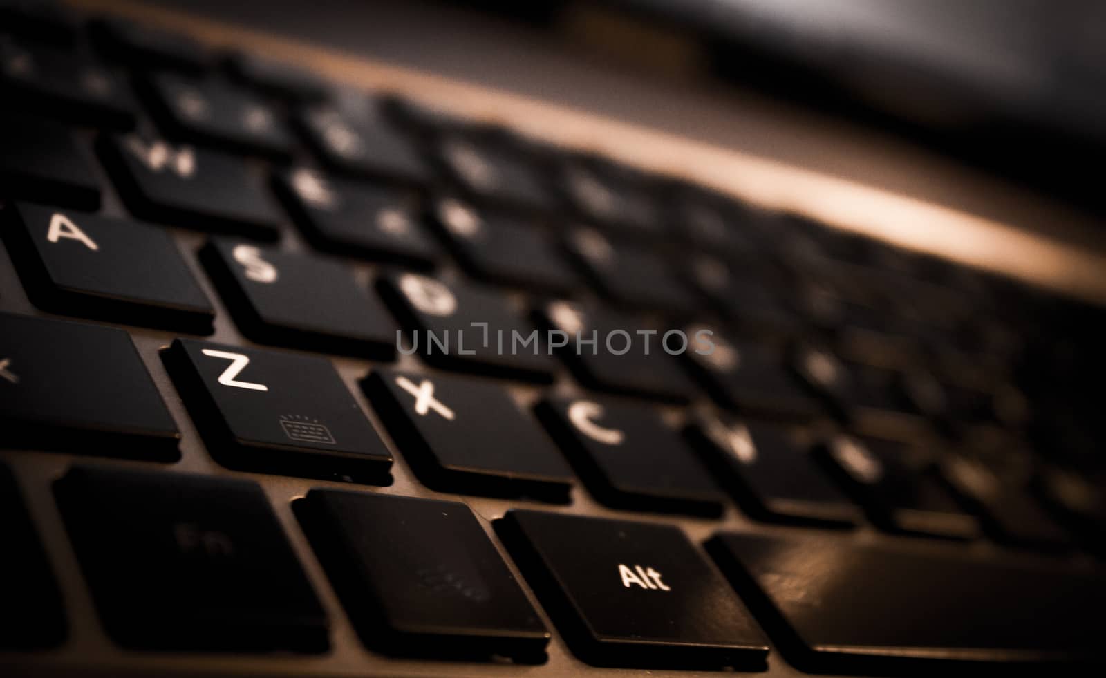 Part of computer keyboard in dark color. White letters.