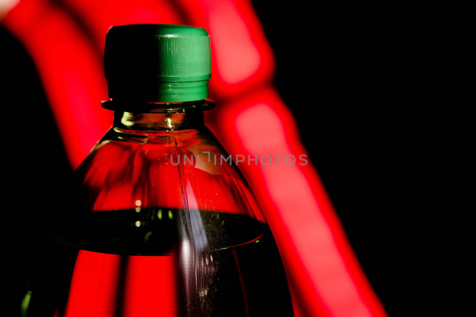 Green plastic bottle on black and red background.