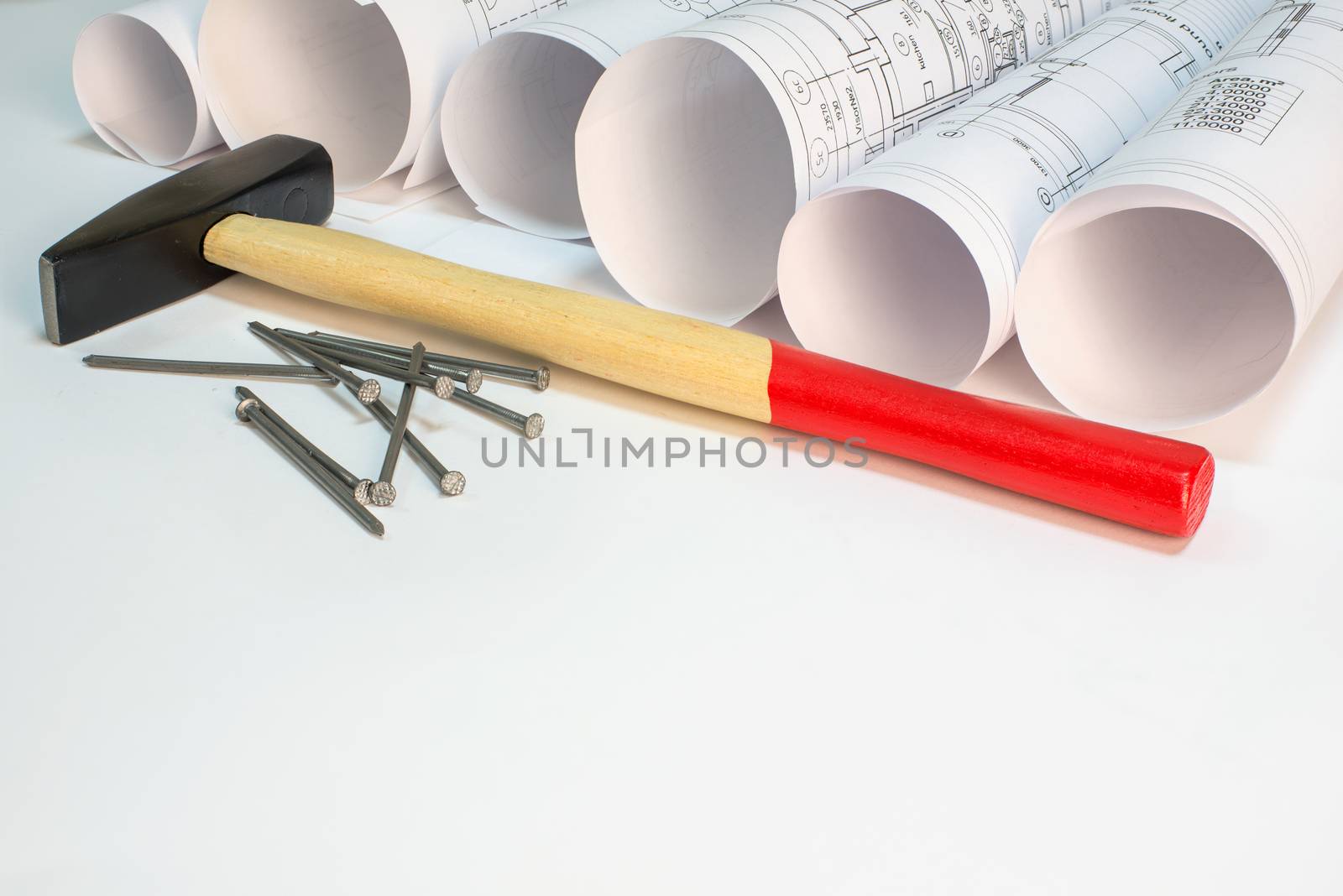 Drawing rolls, hammer and nails on white surface