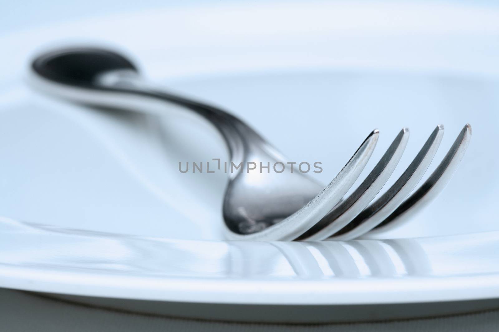 silverware and plate-extreme closeup of a fork - blue tint