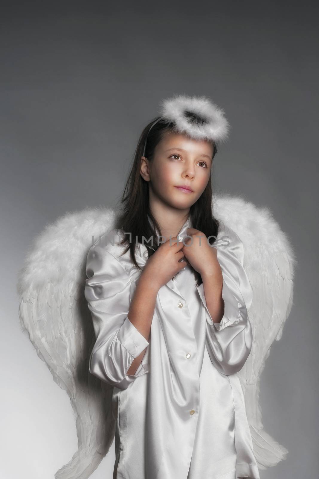 studio portrait of an eleven years old girl dressed as angel