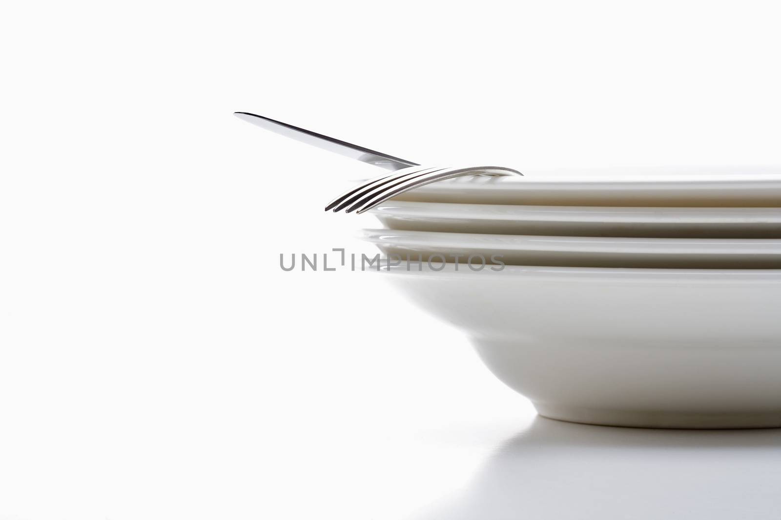 white plates with silverware isolated on white