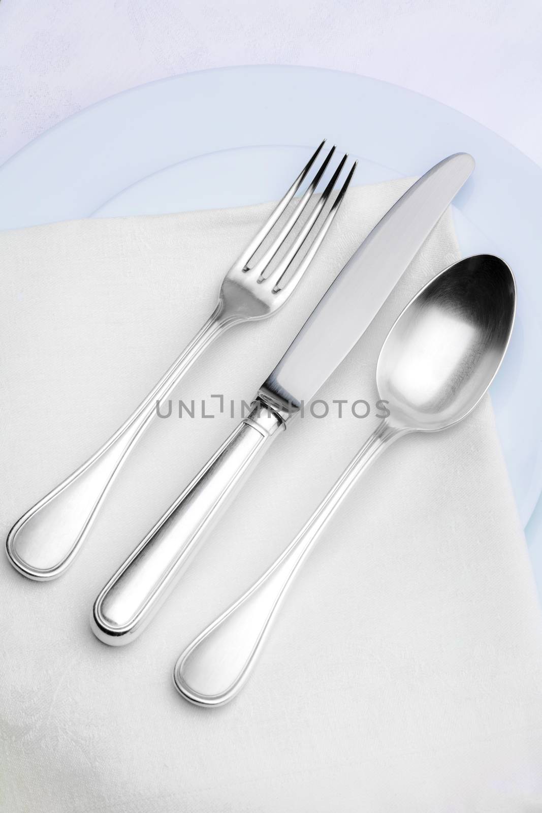 elegant silverware setting on plate with white cloth