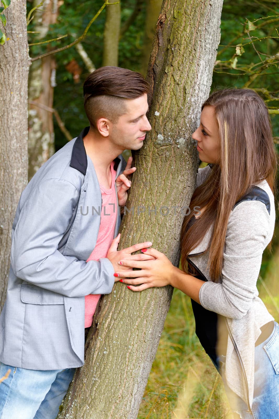 portrait of happy smiling young couple in love embracing outdoor at sunny day
