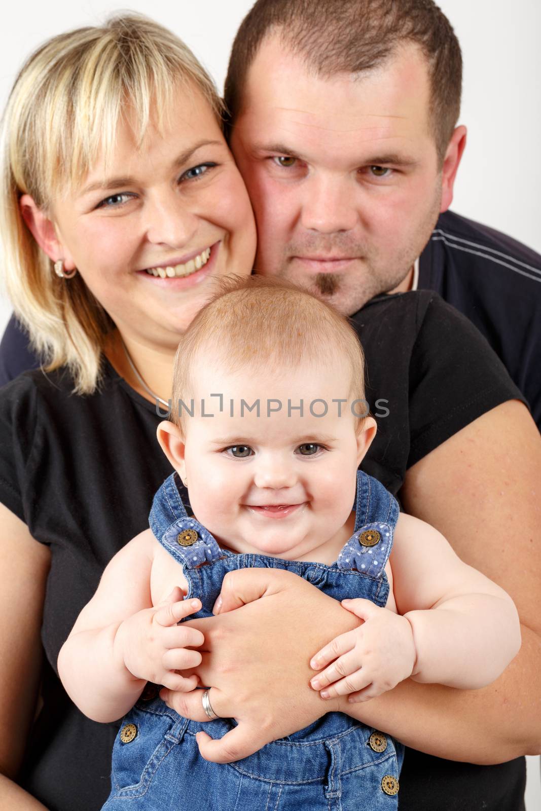 Loving mother and father embracing her baby girl by artush