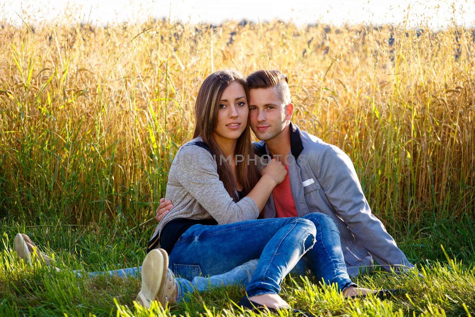 portrait of happy smiling young couple in love embracing outdoor at sunny day