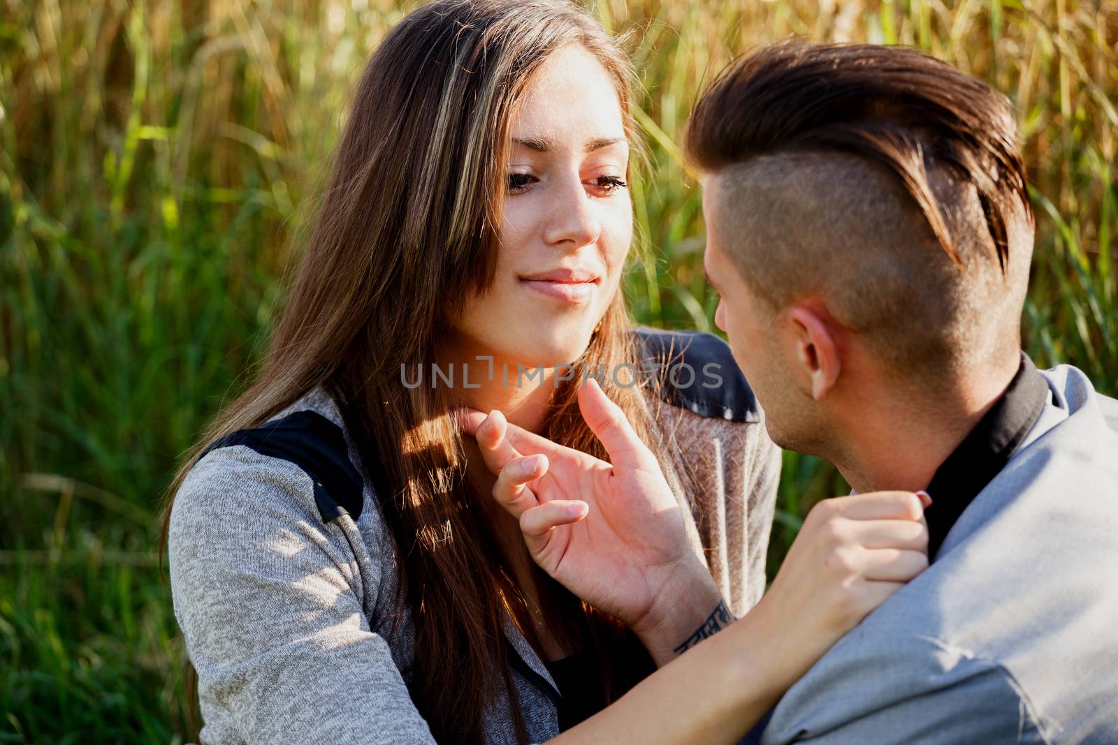 portrait of happy smiling young couple in love embracing outdoor at sunny day