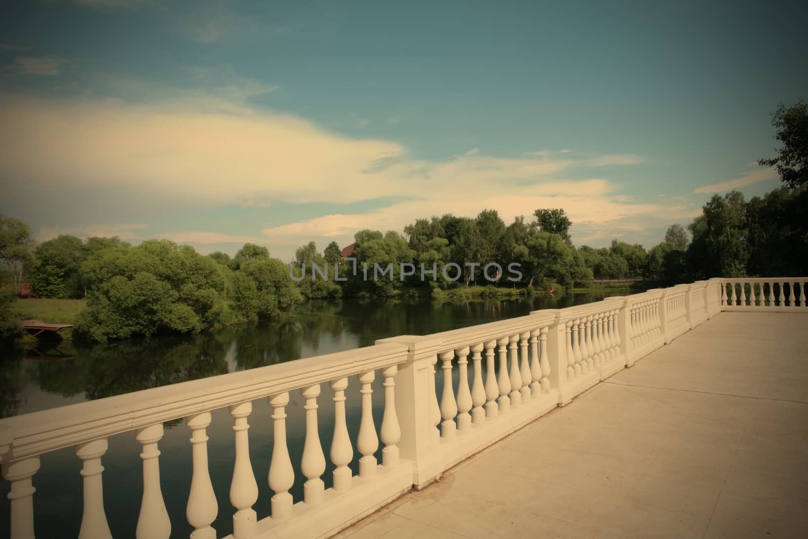 white balustrade ashore calm river under blue sky, instagram image style