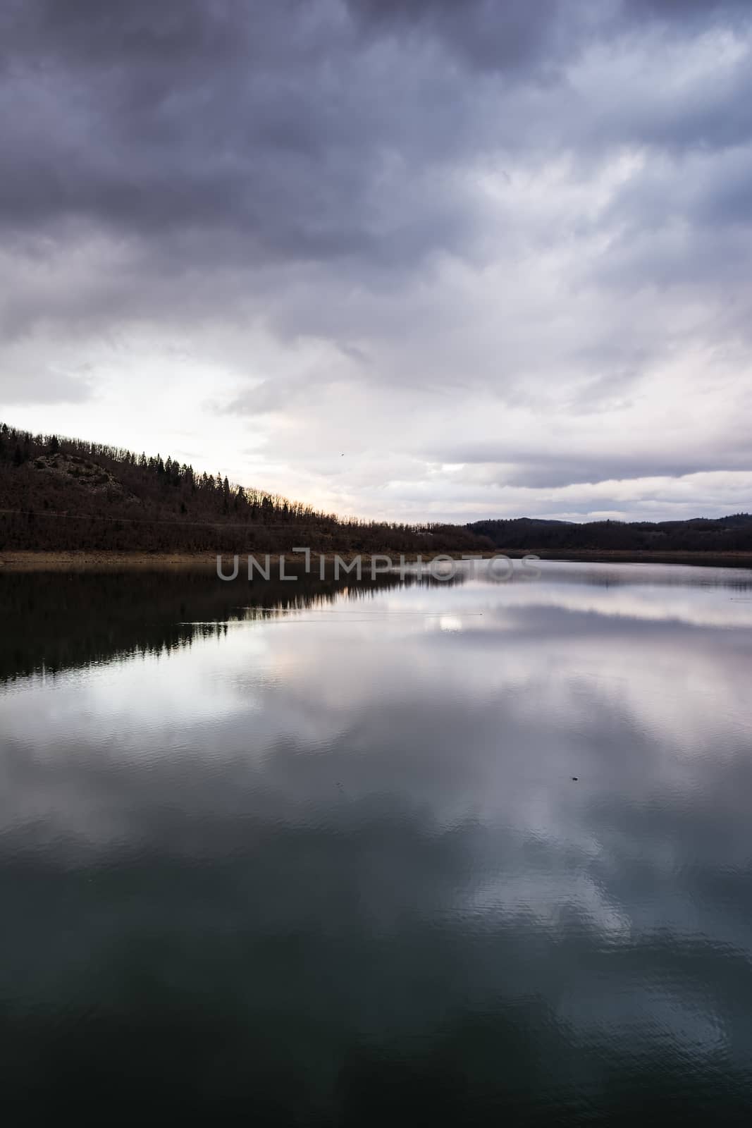 Plastiras lake view with sky reflected in water, in central Greece