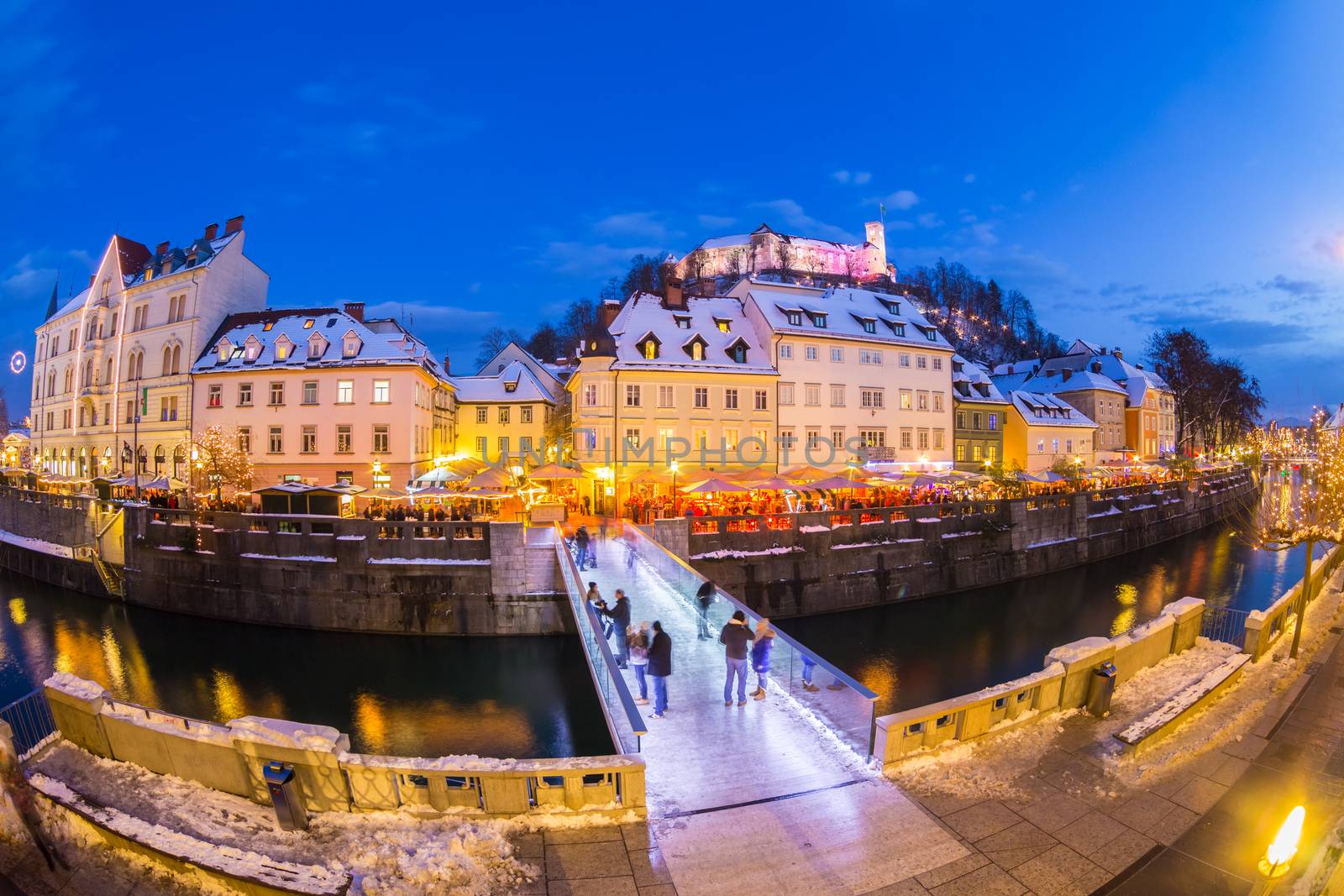 Ljubljana in Christmas time. Lively nightlife in old medieval city center decorated with Christmas lights. Slovenia, Europe. Shot at dusk with fish eye lens.