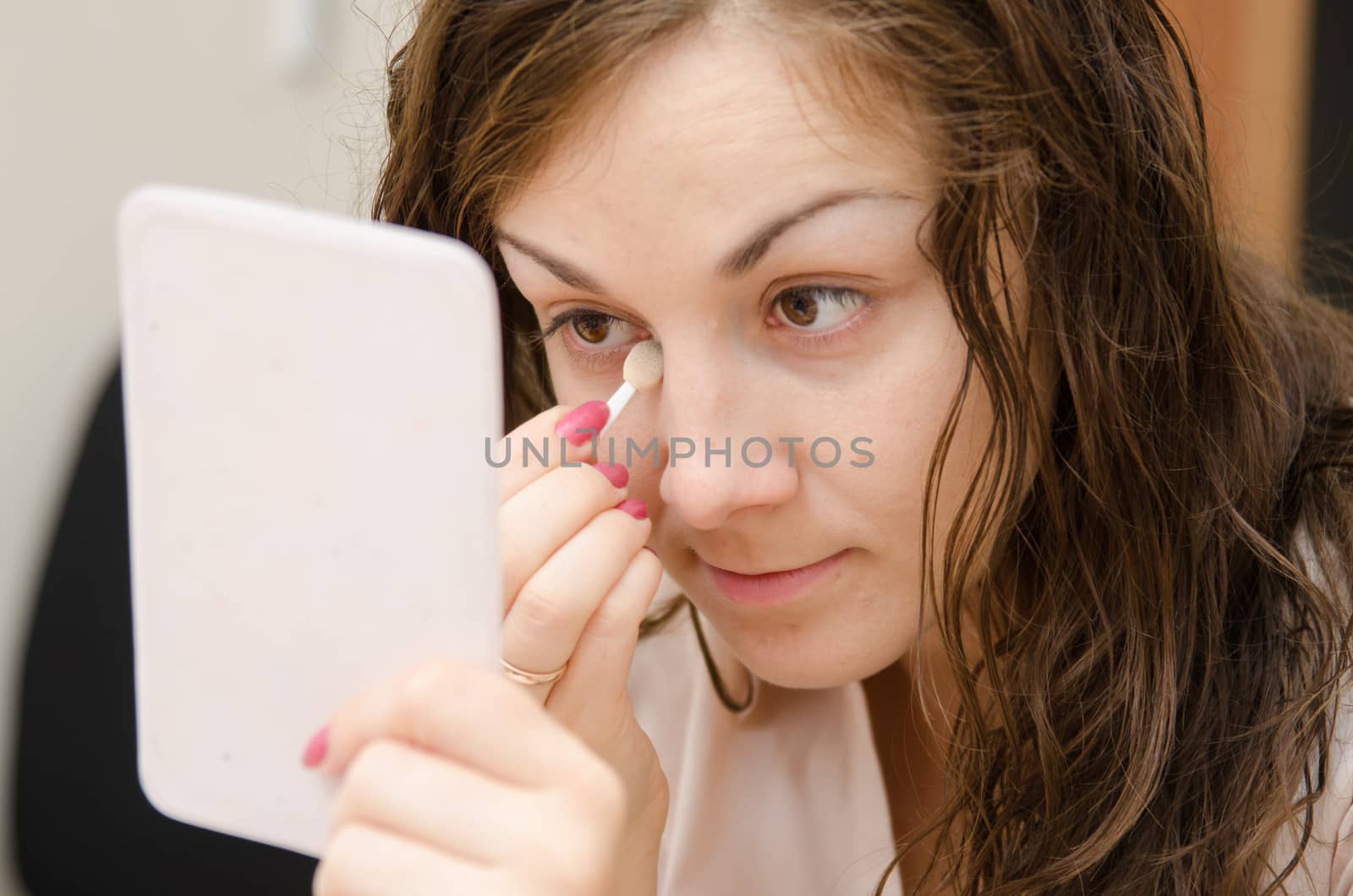 Young girl puts makeup in the office workplace