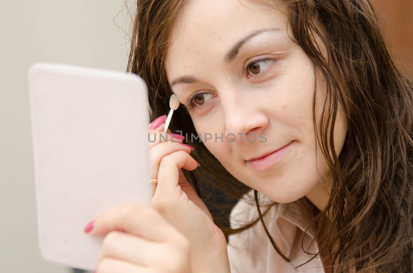 Young girl puts makeup in the office workplace