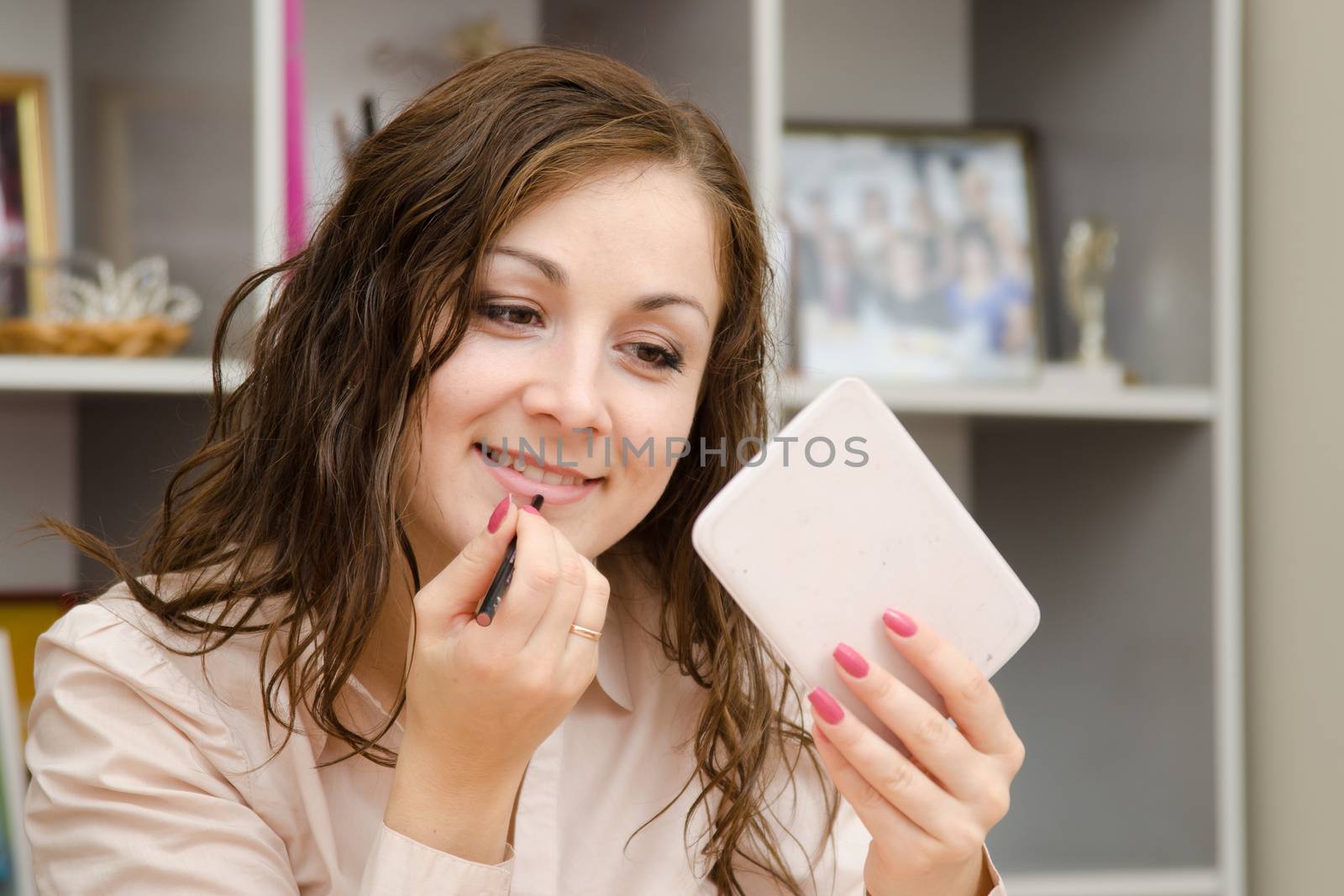 A young girl puts makeup in the office workplace