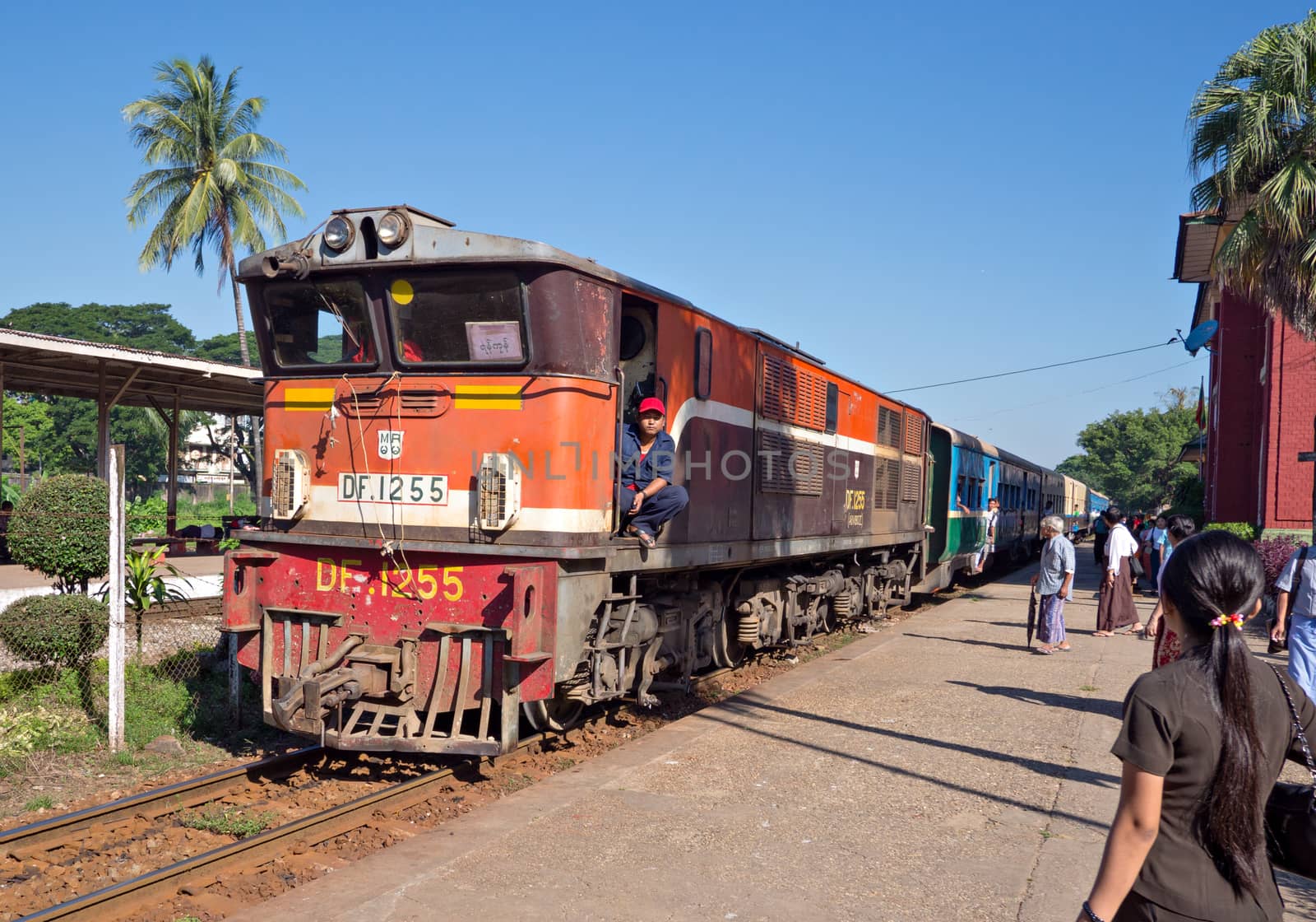 Yangon, Myanmar - November 13, 2014: Train arriving at Pan Hlaing Railway Station in Yangon, Myanmar. Myanmar has an extensive railway network, but trains and staitions are mostly old and run down.