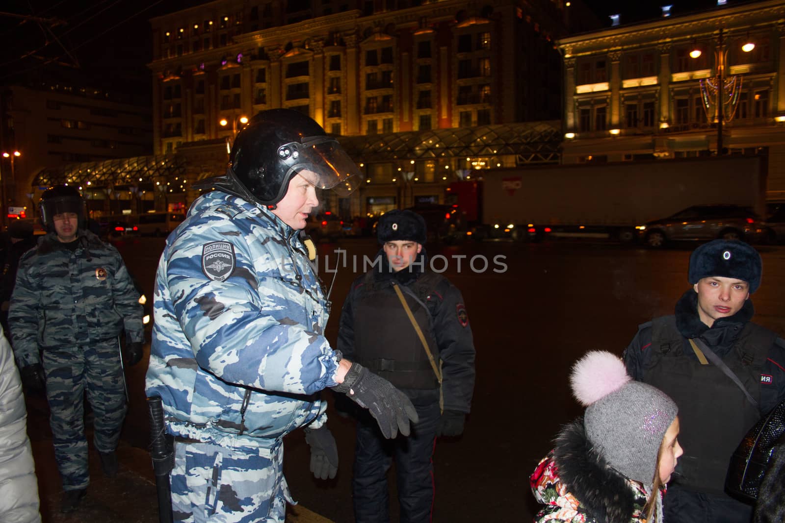 Moscow, Russia - December 30, 2014. In day of a sentence to the oppositional leader Alexei Navalny and his brother Oleg Navalny Muscovites came to a protest action to Manezhnaya Square. The police officer sees off the child through a place of a protest action