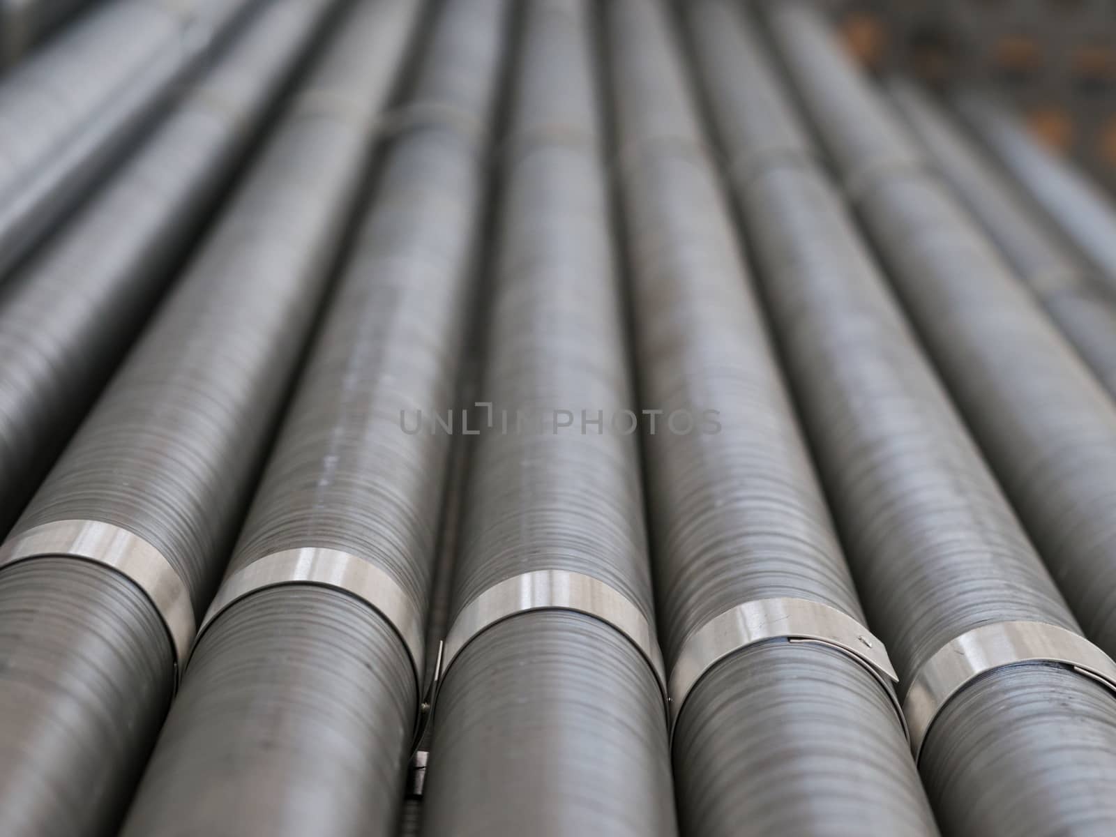 Cooling pipes with ribs from an industrial air cooled condenser. Very shallow depth of field with the metal bands in focus.