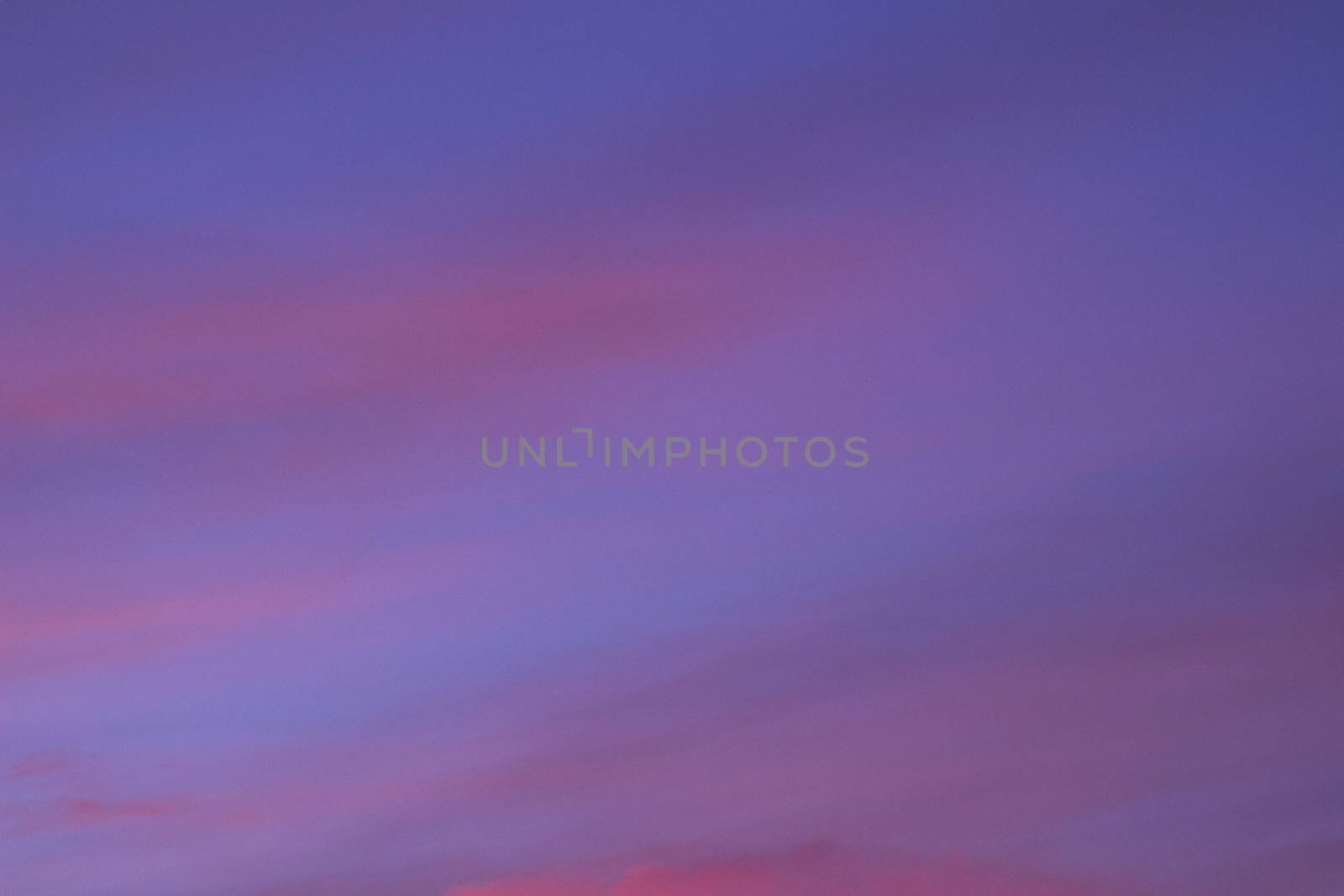 Sky with clouds in blue and pink purple sunset evening pastel colors photo.