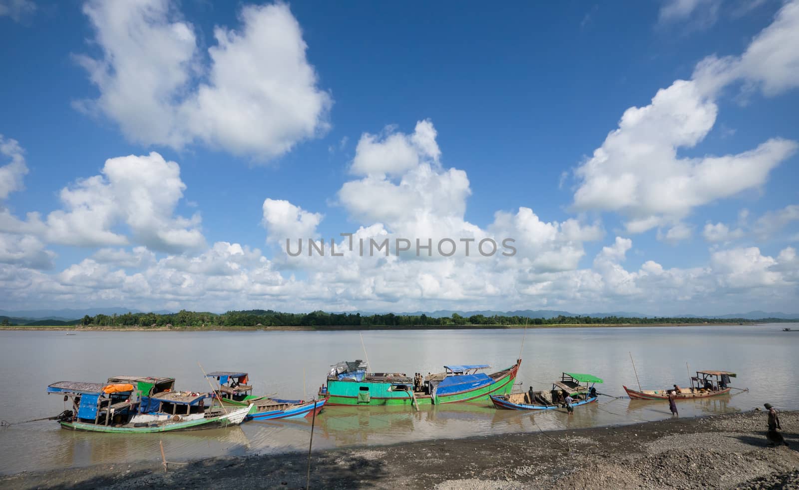 Lay Myo River, Rakhin State, Myanmar - October 17, 2014: Vessels unloading gravel and rocks for road construction that has been found further upstream.