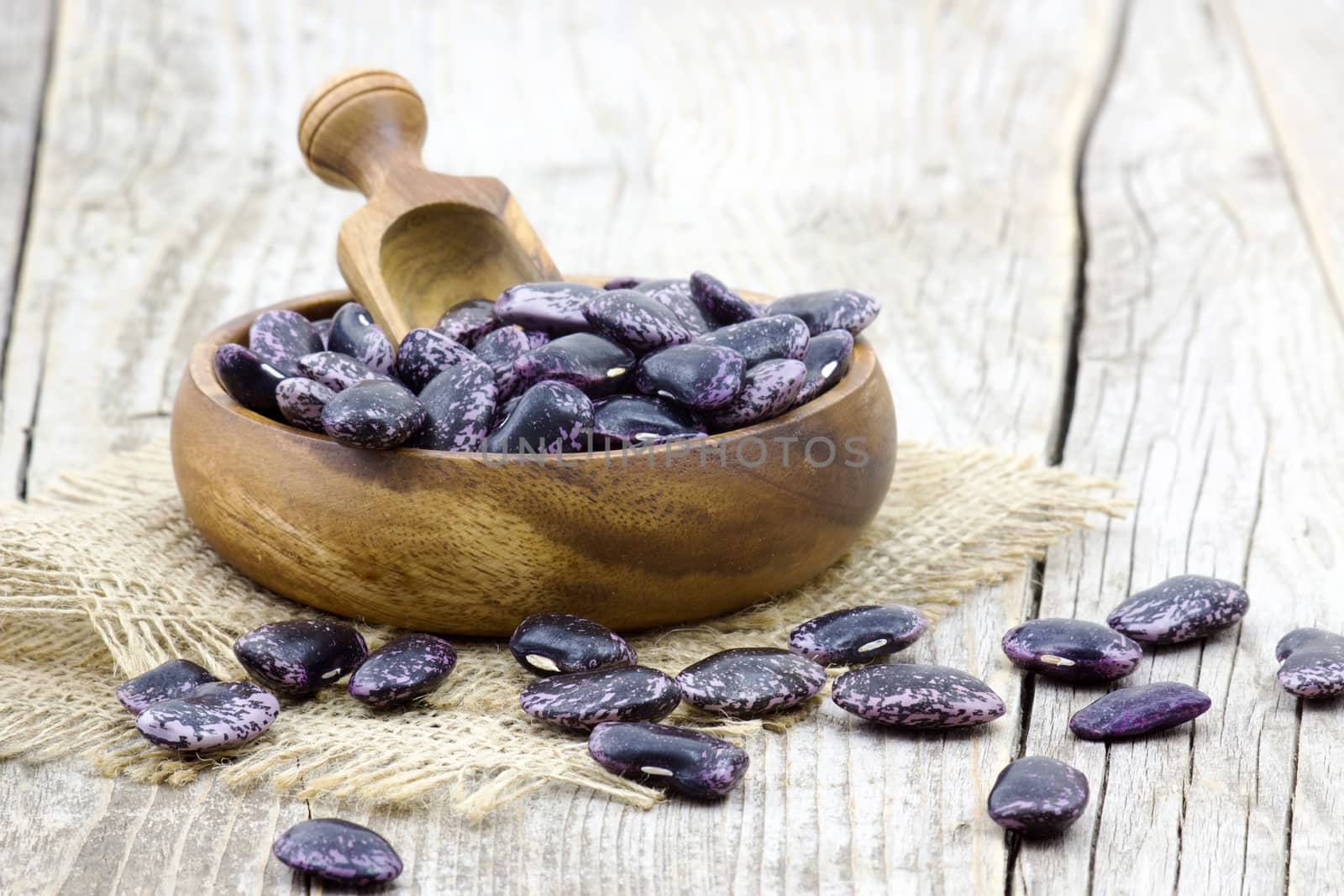 Beans in bowl on wooden background  by miradrozdowski