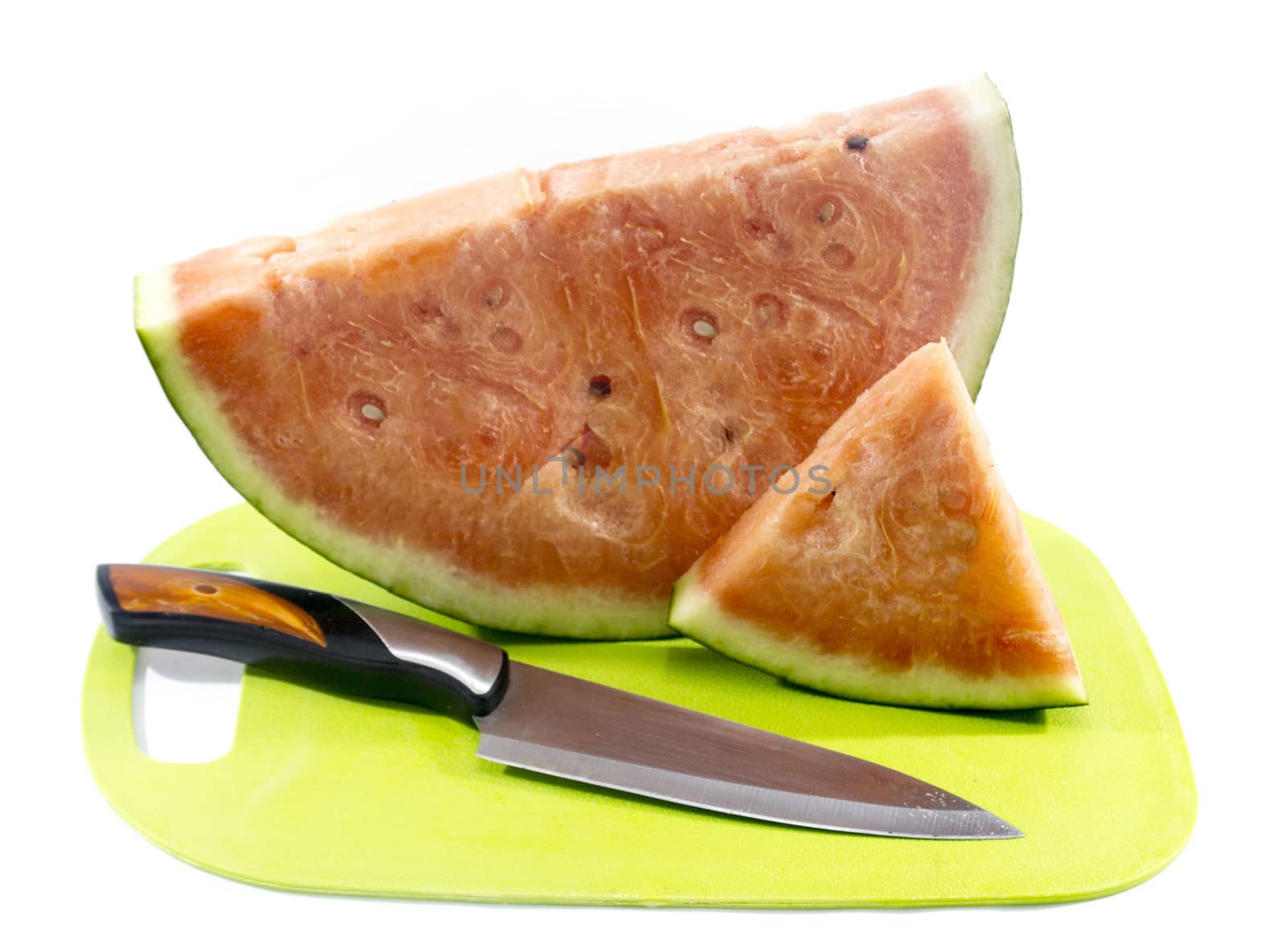Slices of watermelon on green plastic board with knife.