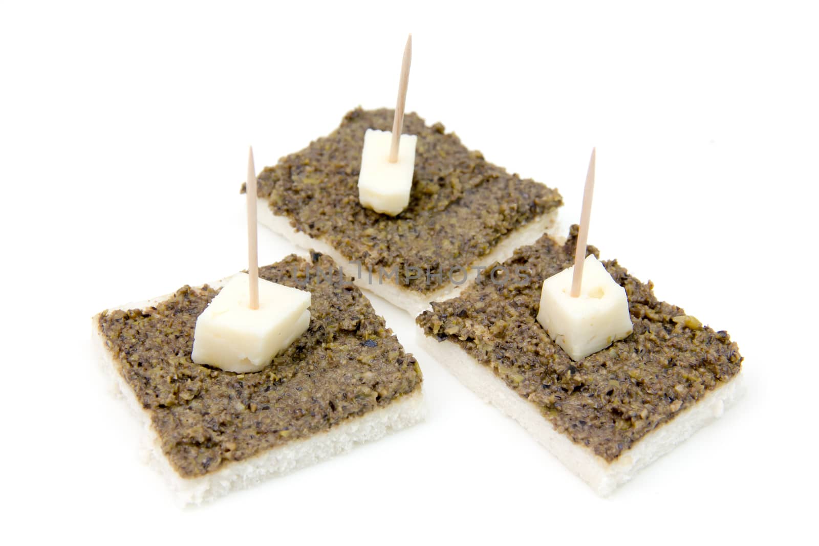 Canapes with olive paste on white background