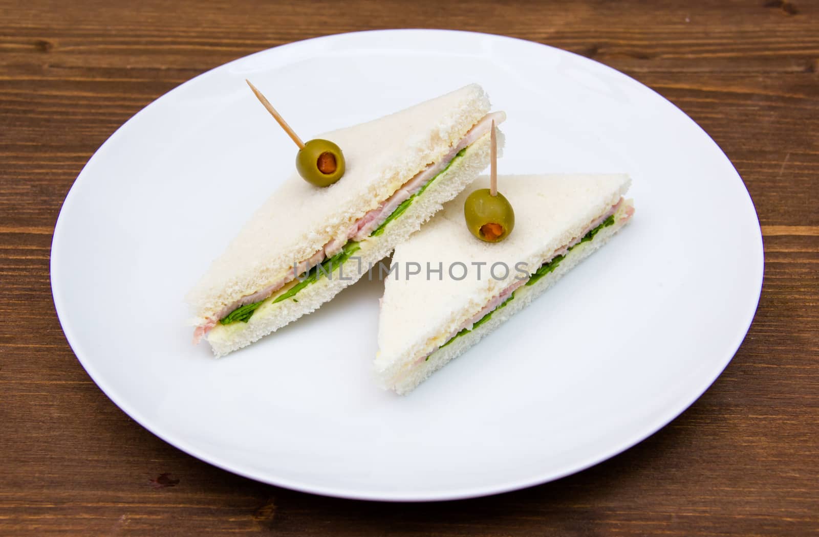 Triangular sandwiches on plate on wooden table