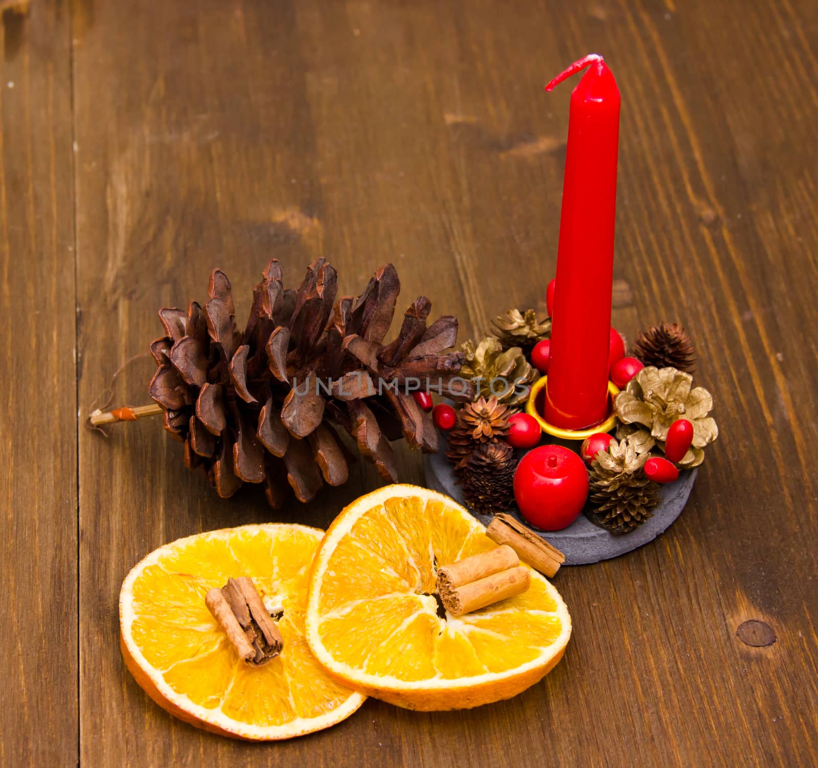 Candle with Christmas decorations on wooden table close up view