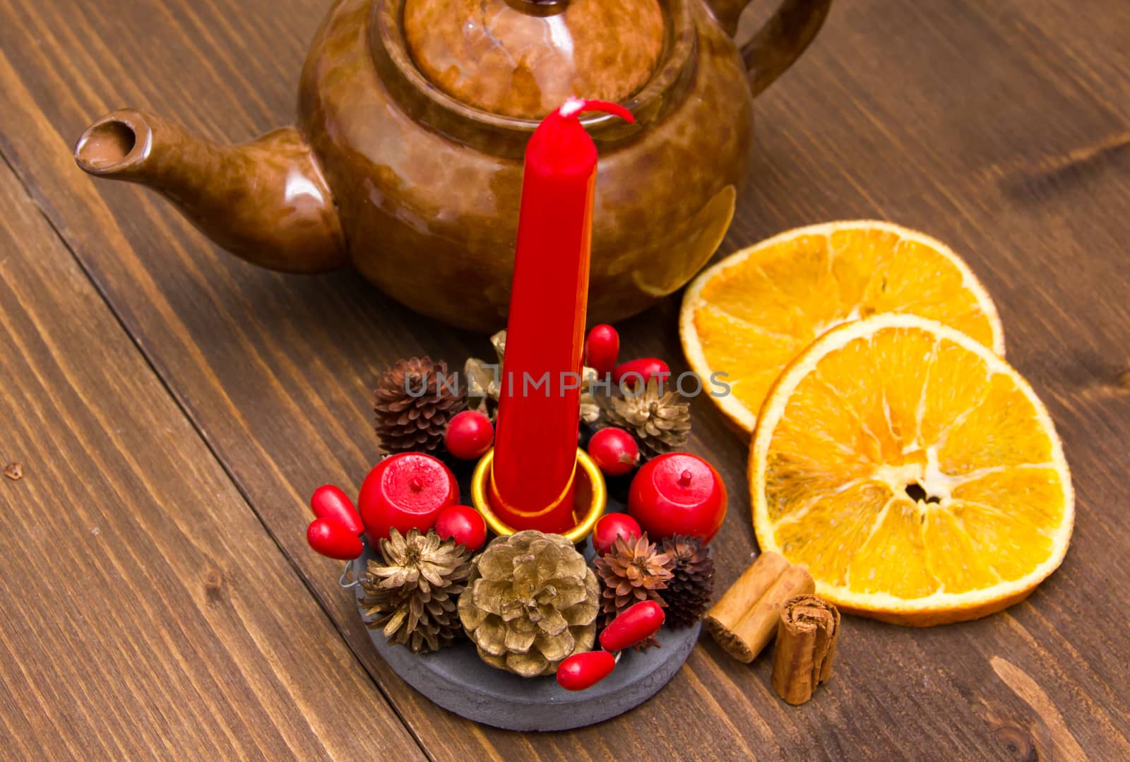 Christmas candle with orange and cinnamon on wooden table top view