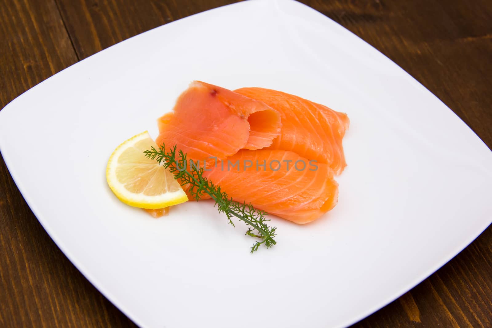 Smoked salmon on plate on wooden table