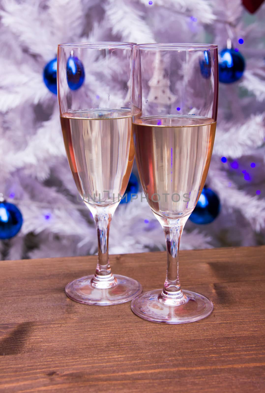 Flute with sparkling wine in front of Christmas tree