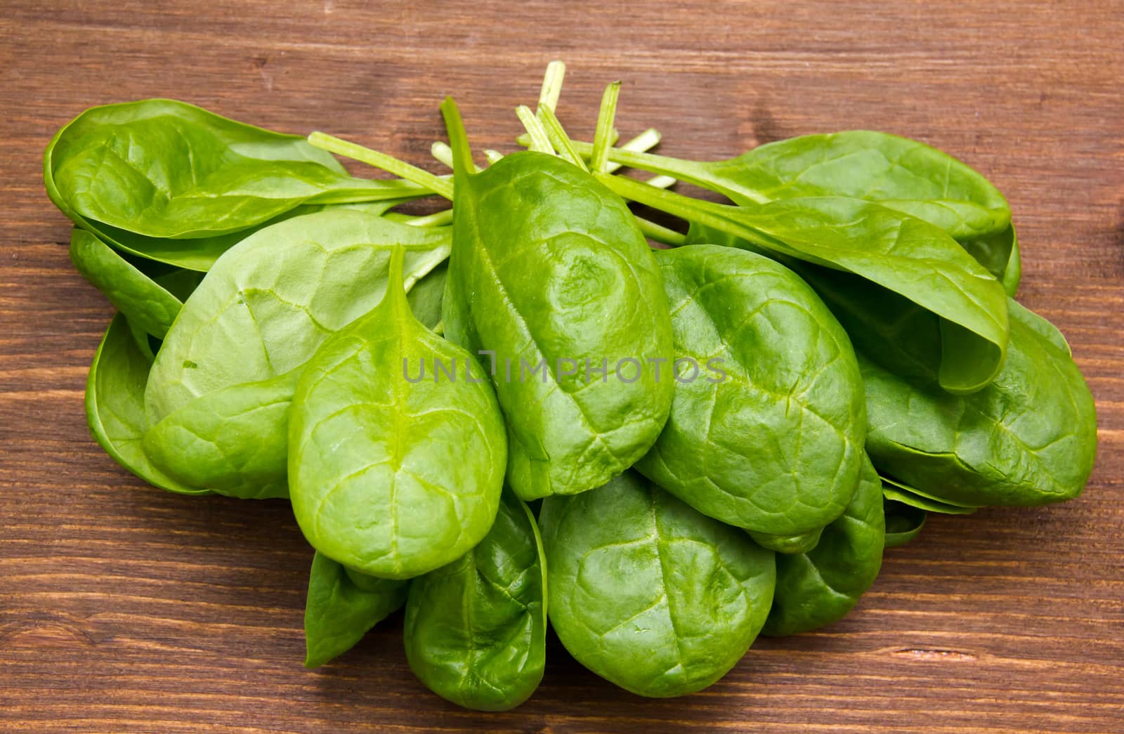 Fresh spinach leaves on wooden table top views