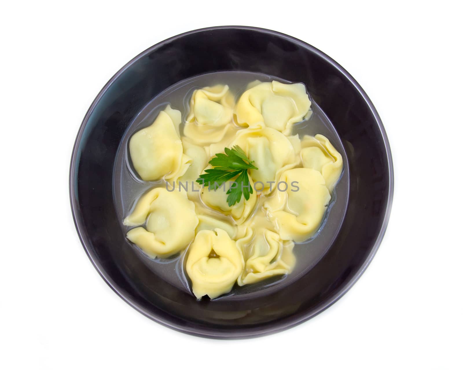 Tortellini soup on white background from above