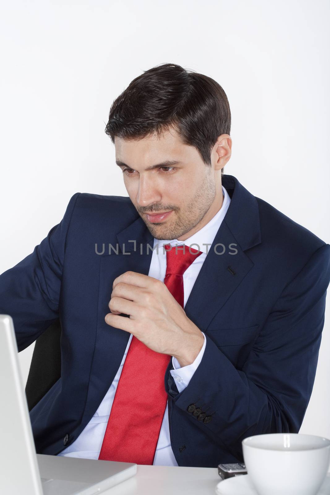 young business executive in suit behind desk with laptop