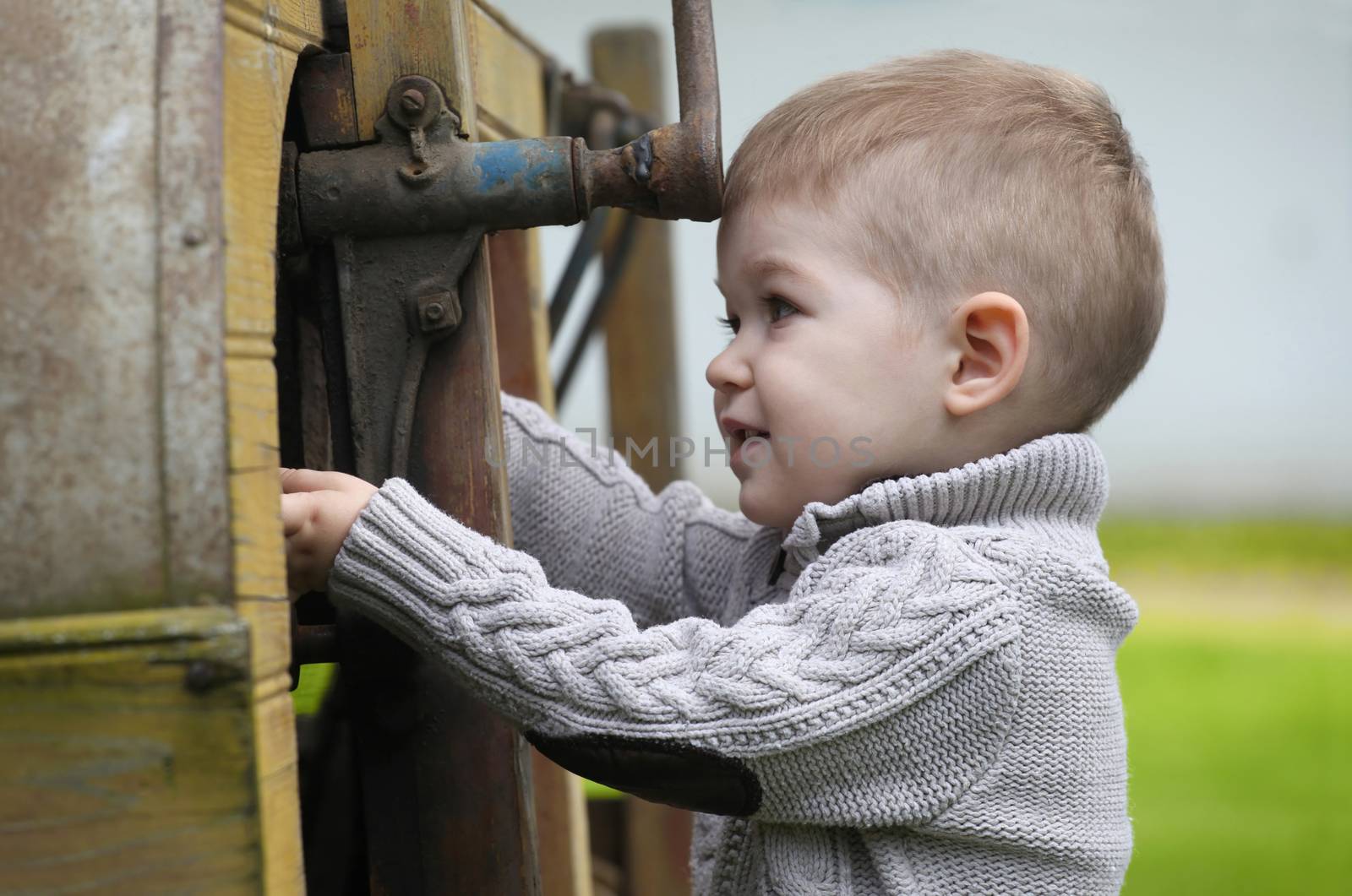 2 years old curious Baby boy managing with old agricultural Mach by vladacanon