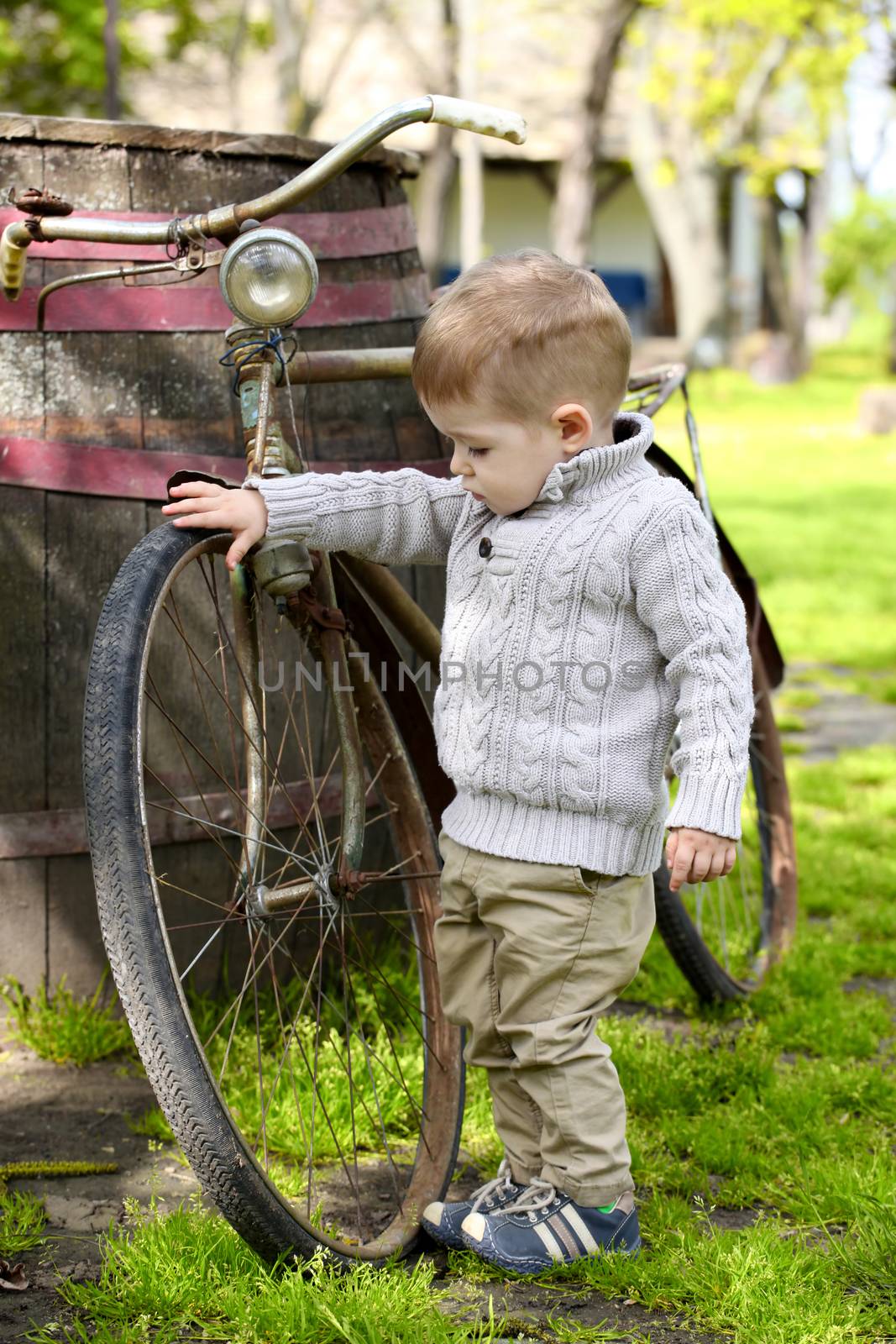 2 years old curious Baby boy walking around the old bike  by vladacanon