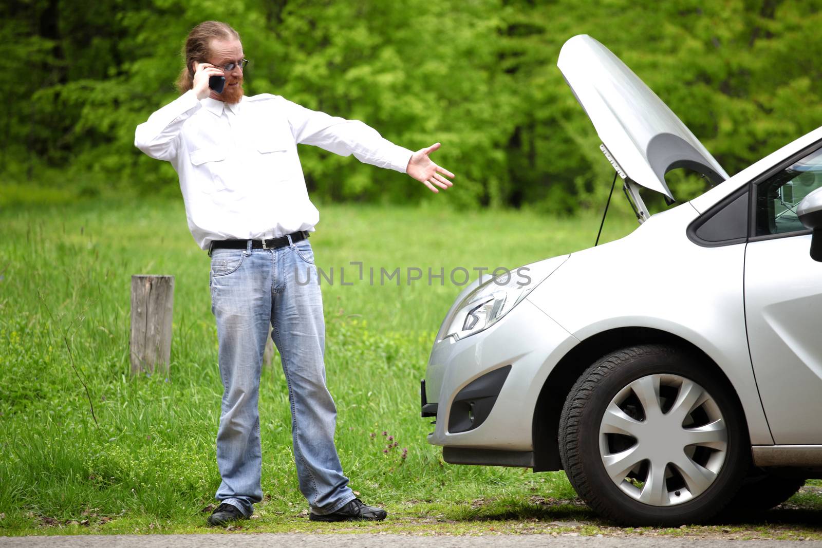 Driver furious with mobile phone a broken car by the road