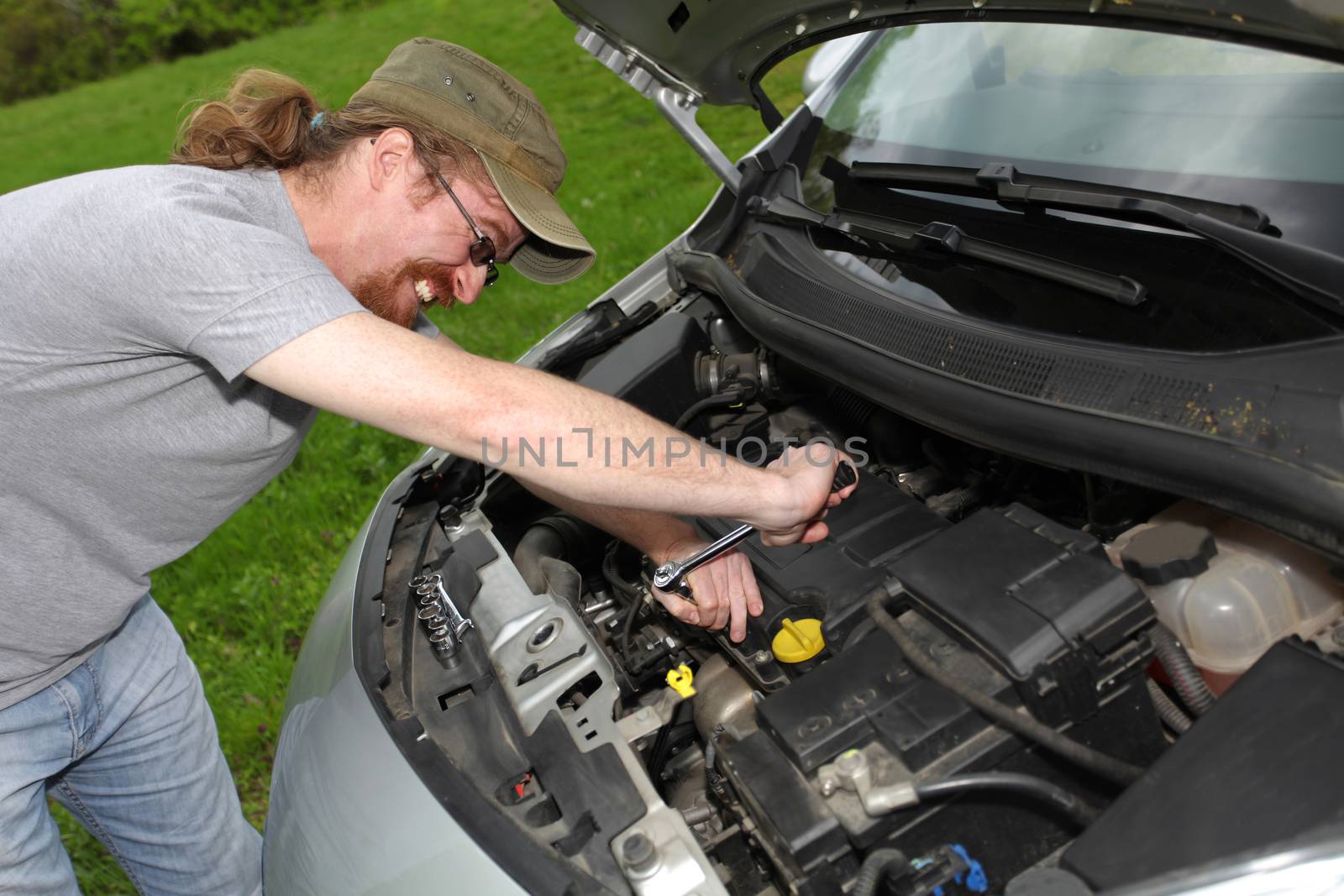 mechanic repairs a car on the road