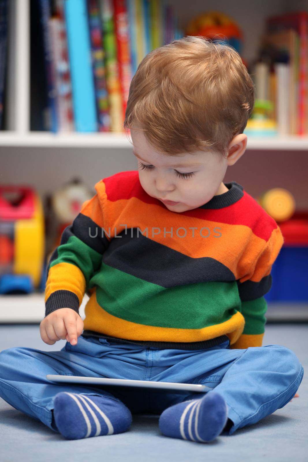 Happy 2 years old boy using a digital tablet computer