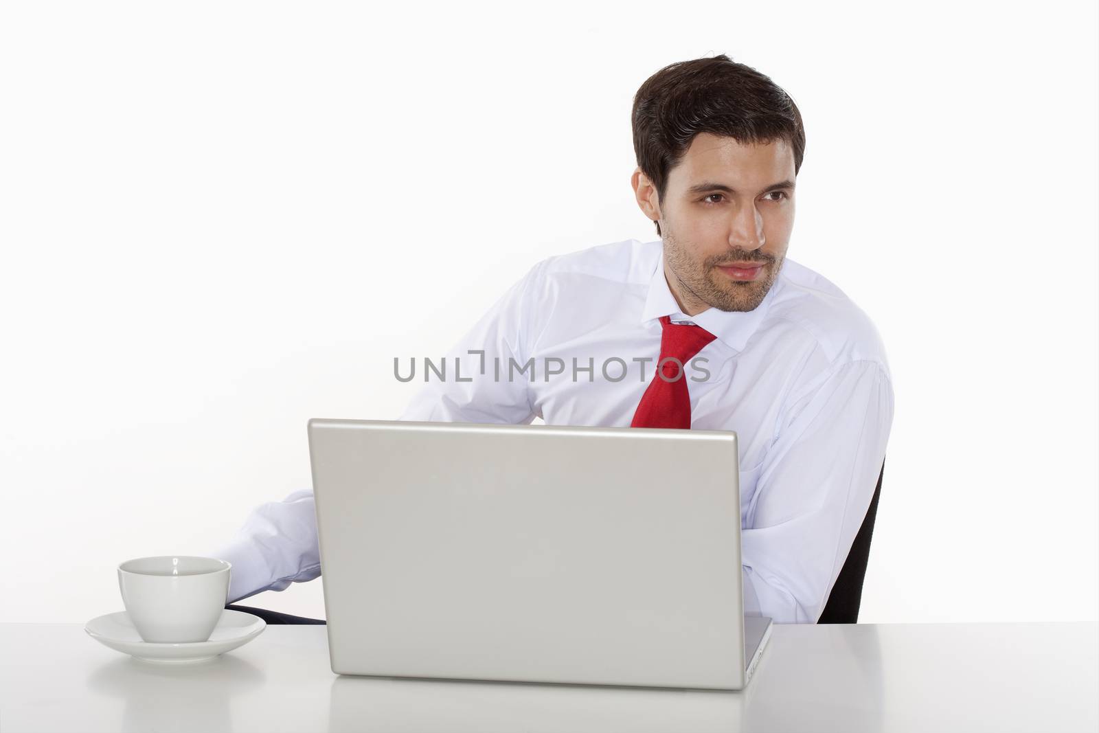 business executive in white shirt behind desk with laptop