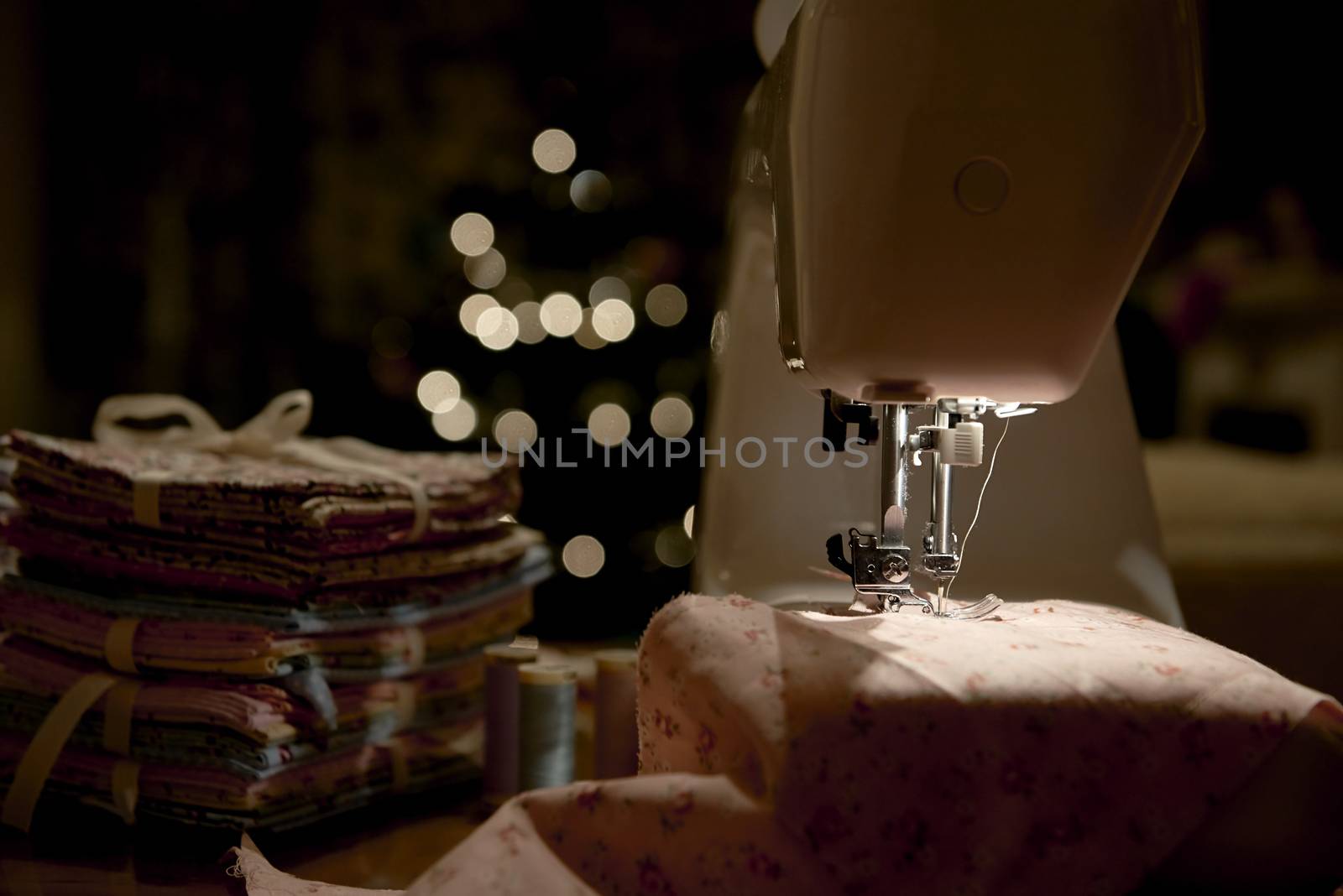 Low key detail of automatic sewing machine, shot from the side
