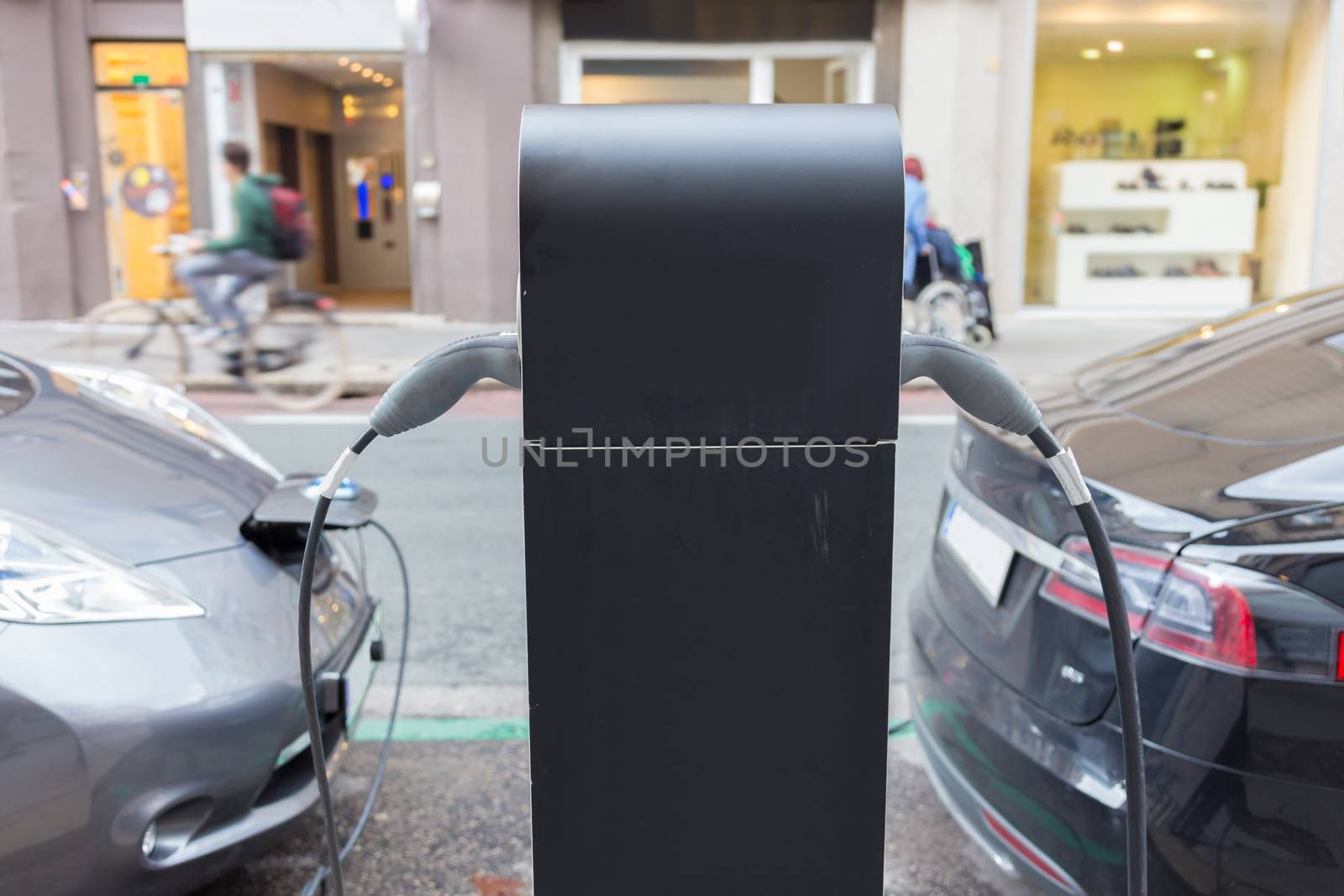 Power supply for electric car charging.  Electric cars charging station. Power supply plugged into an electric car being charged.