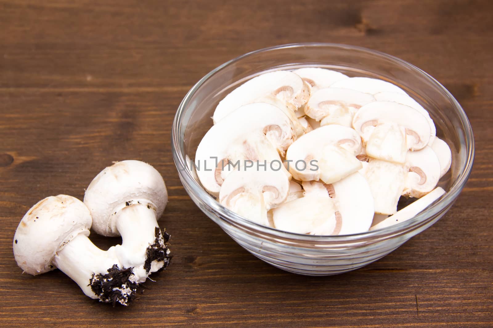 Sliced mushrooms in bowl on wooden table