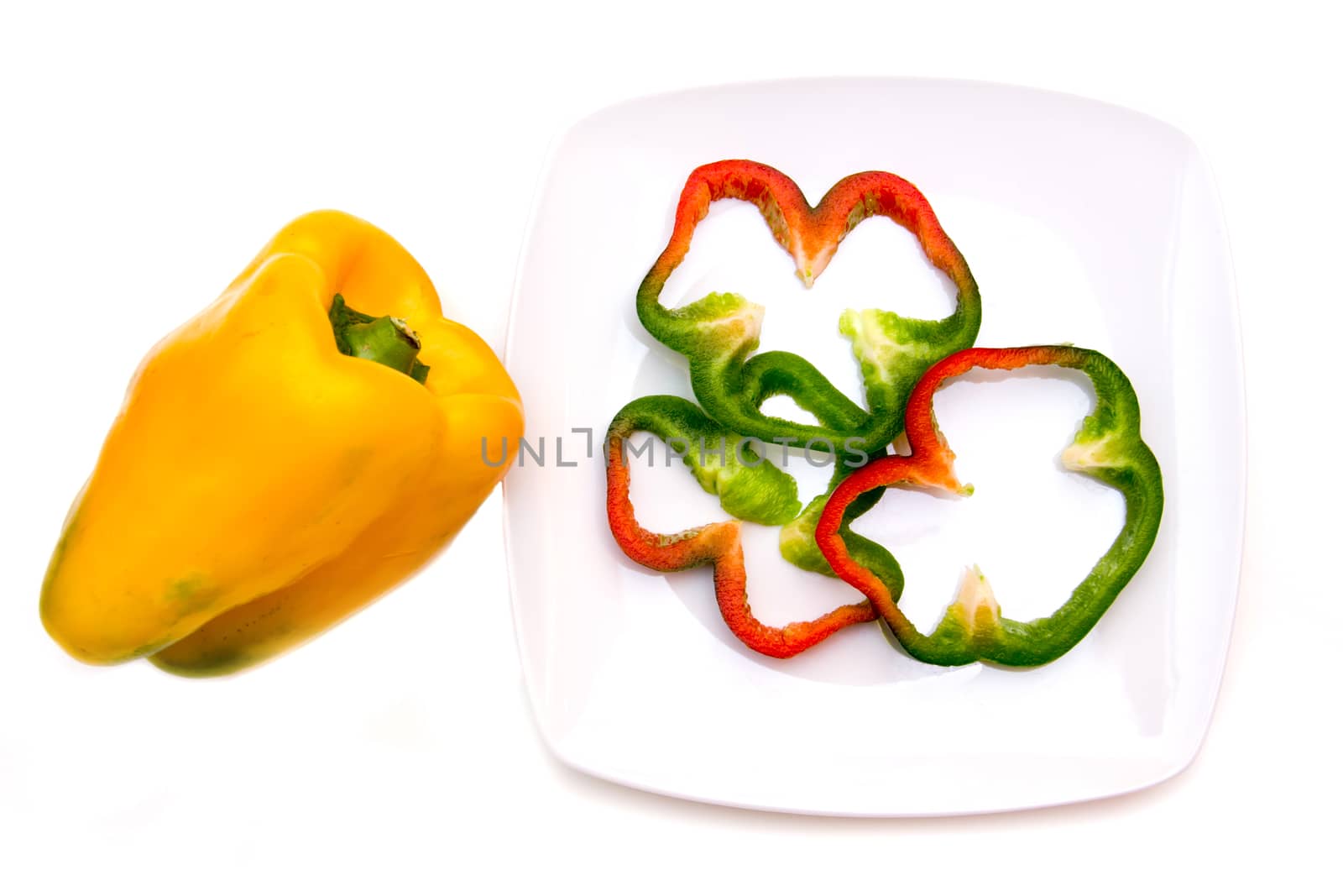 Pepper slices on plate on white background viewed from above