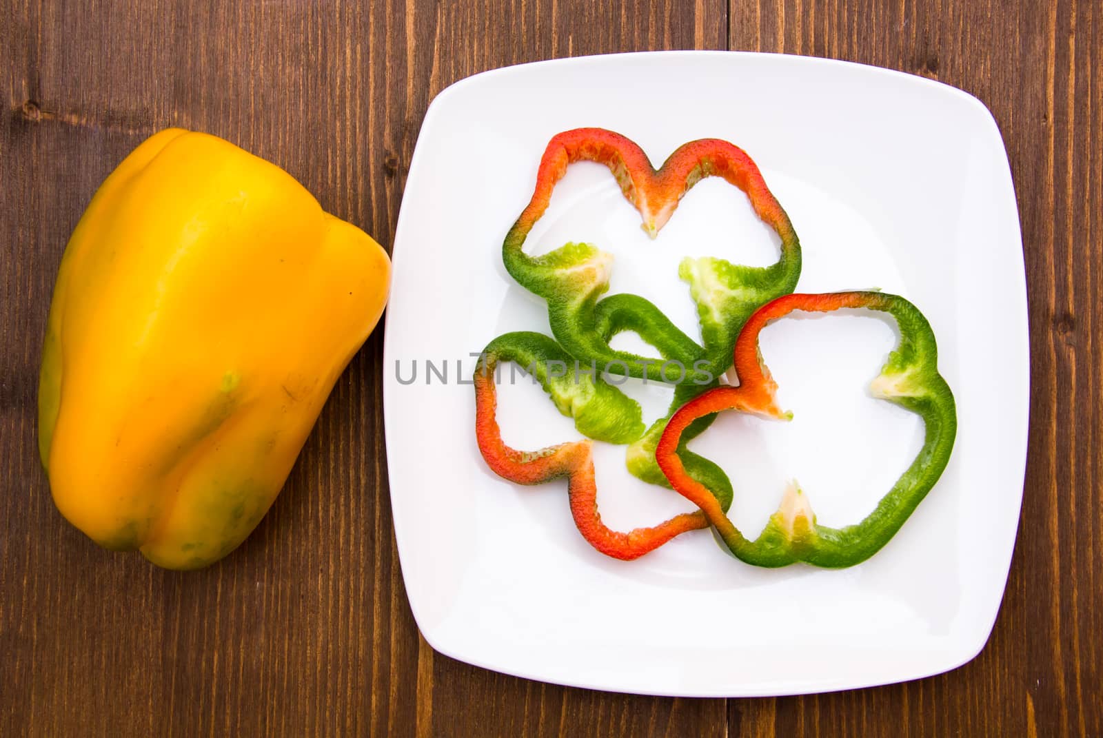 Pepper slices on plate on wooden table top views