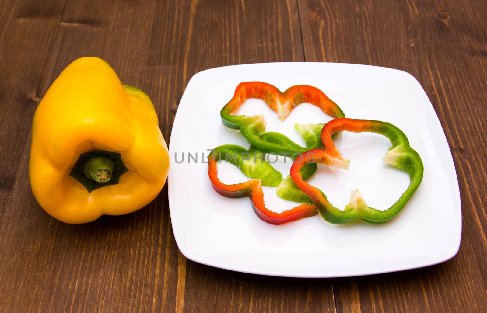 Pepper slices on plate on wooden table