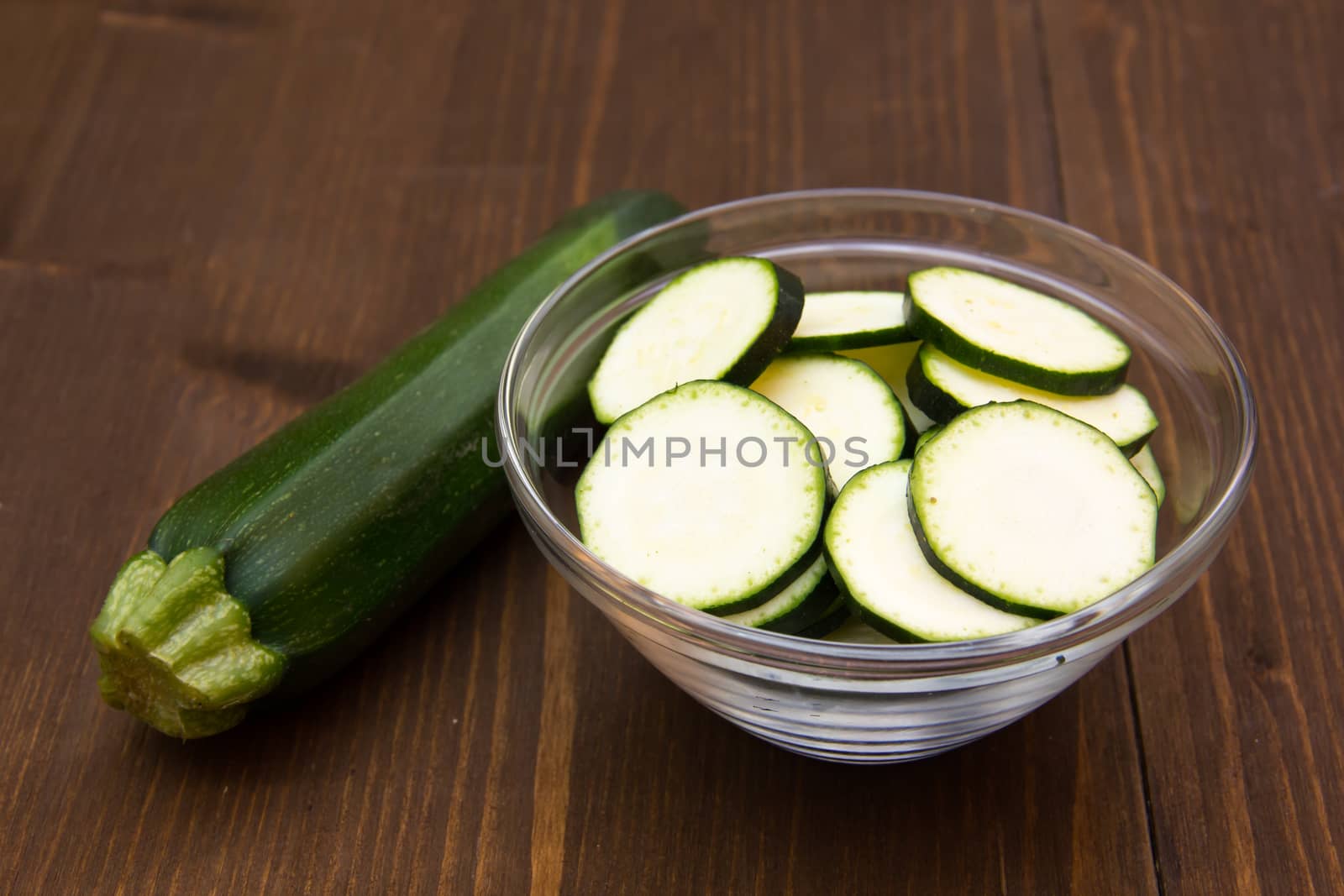 Zucchini slices on bowl on wooden table