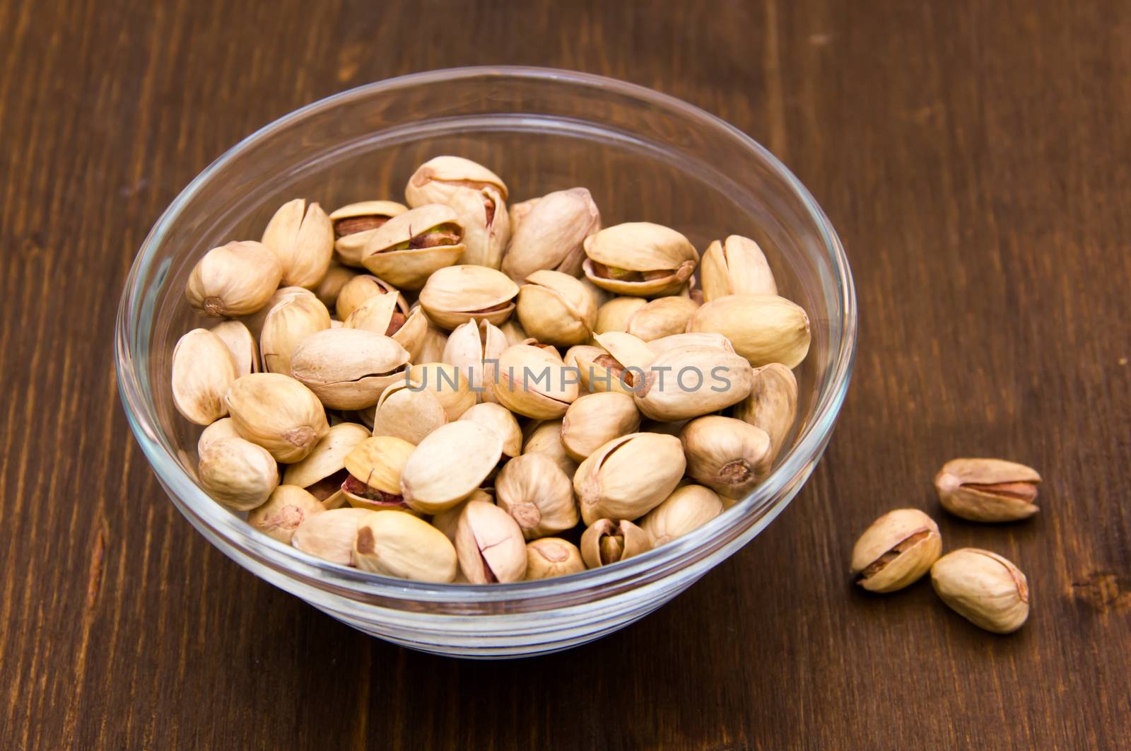Pistachios on bowl on wood by spafra