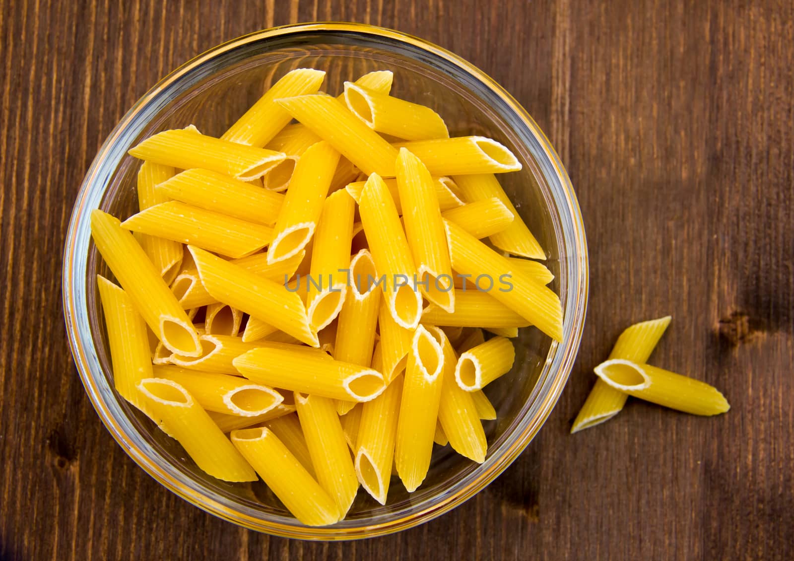 Glass bowl with pasta on the wooden table top view