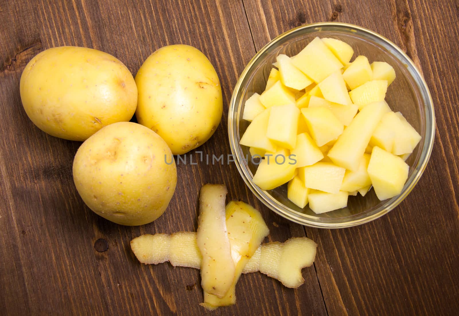 Bowl with potato cubes on wooden table top view