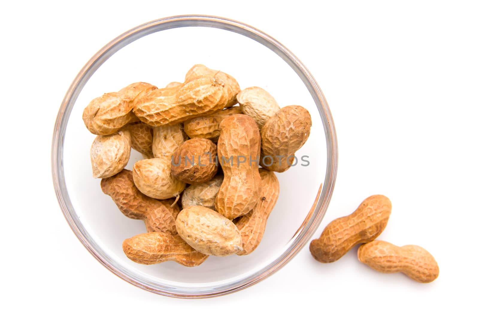 Peanuts on glass bowl on white background top view